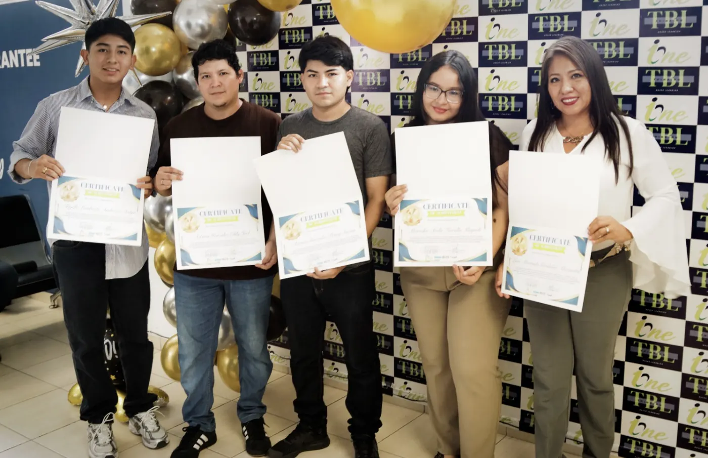 Graduados de I-ONE mostrando sus certificados de inglés