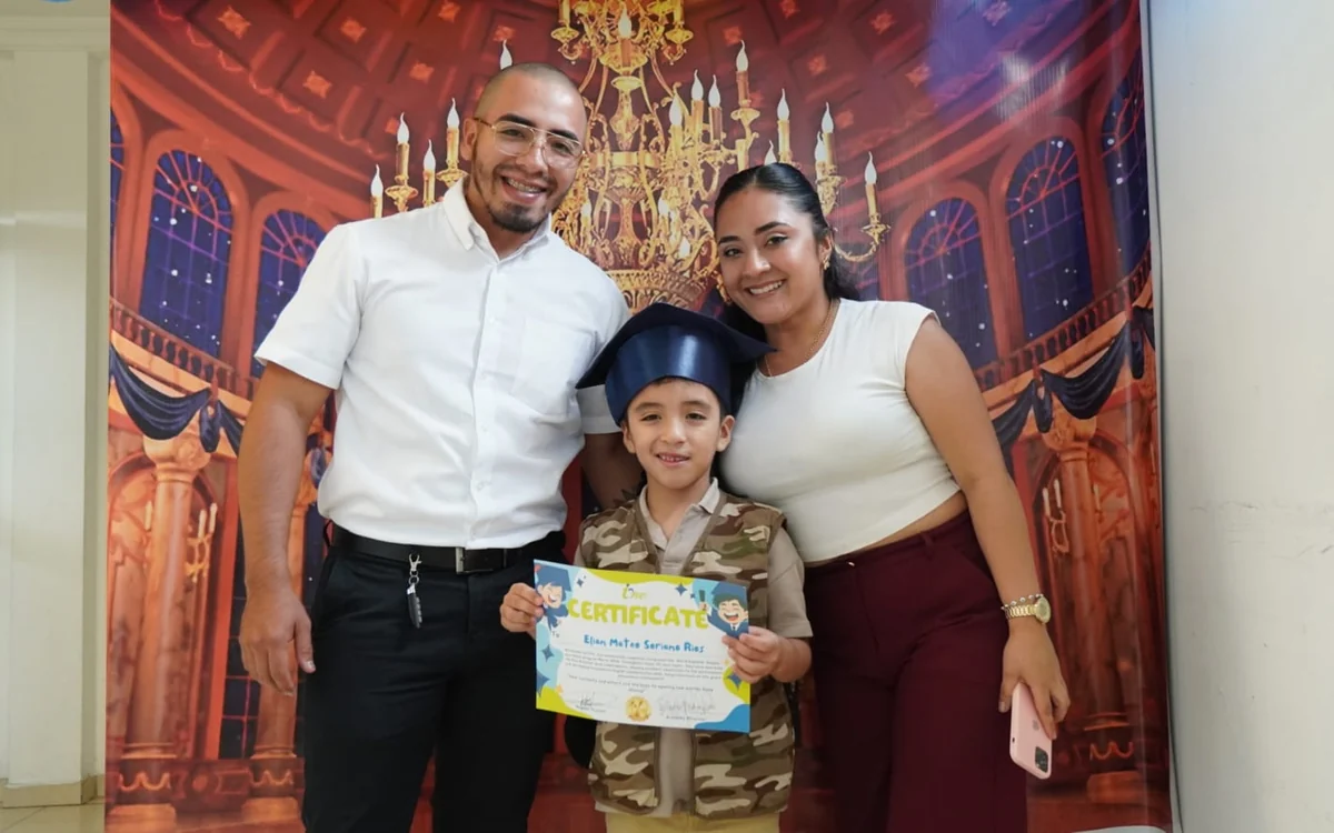 Niño de Only Kids con su certificado y sus padres